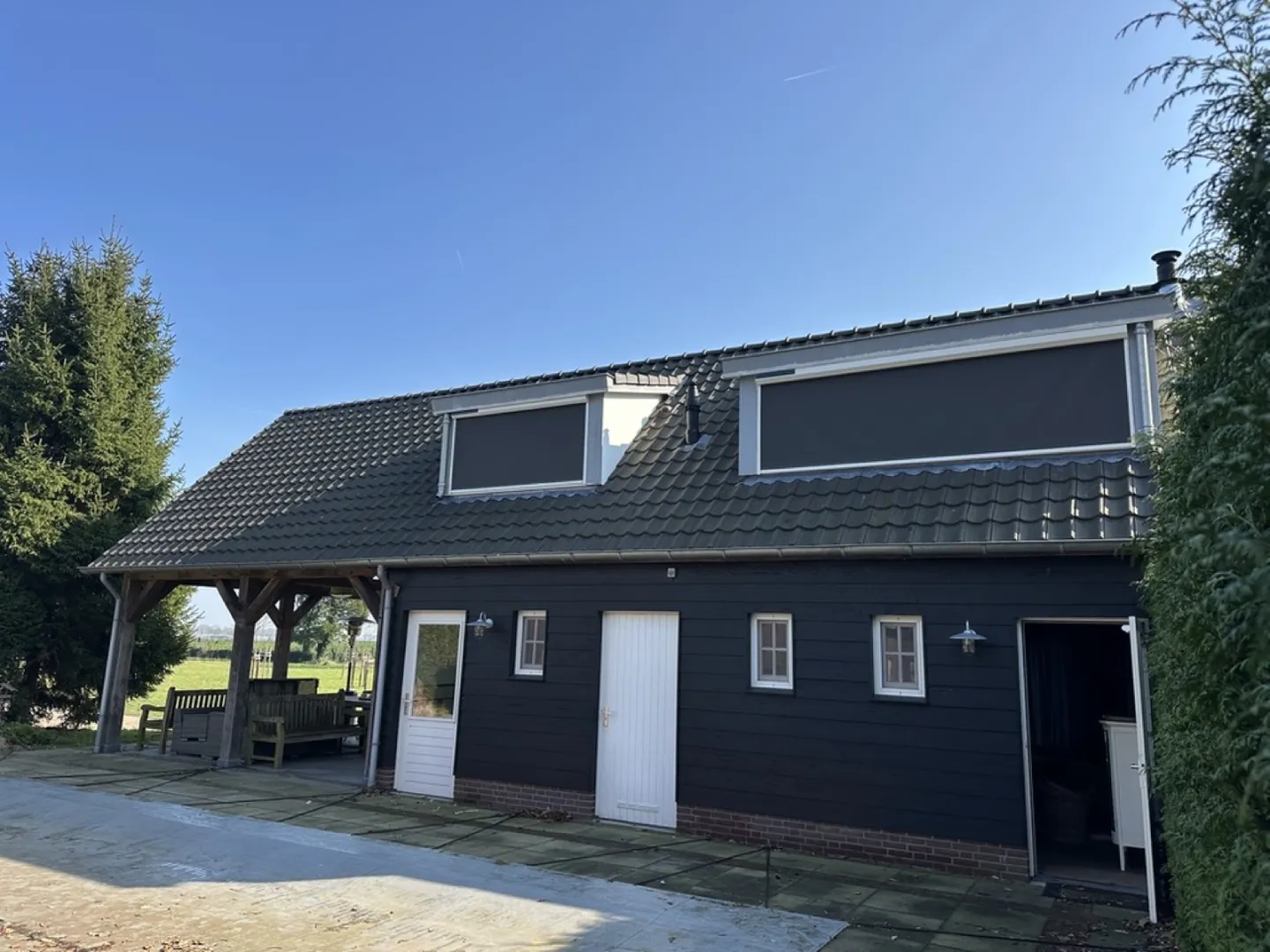 Boerderij met zwarte gevel en screens voor de dakkapellen, gemonteerd door Sunvio