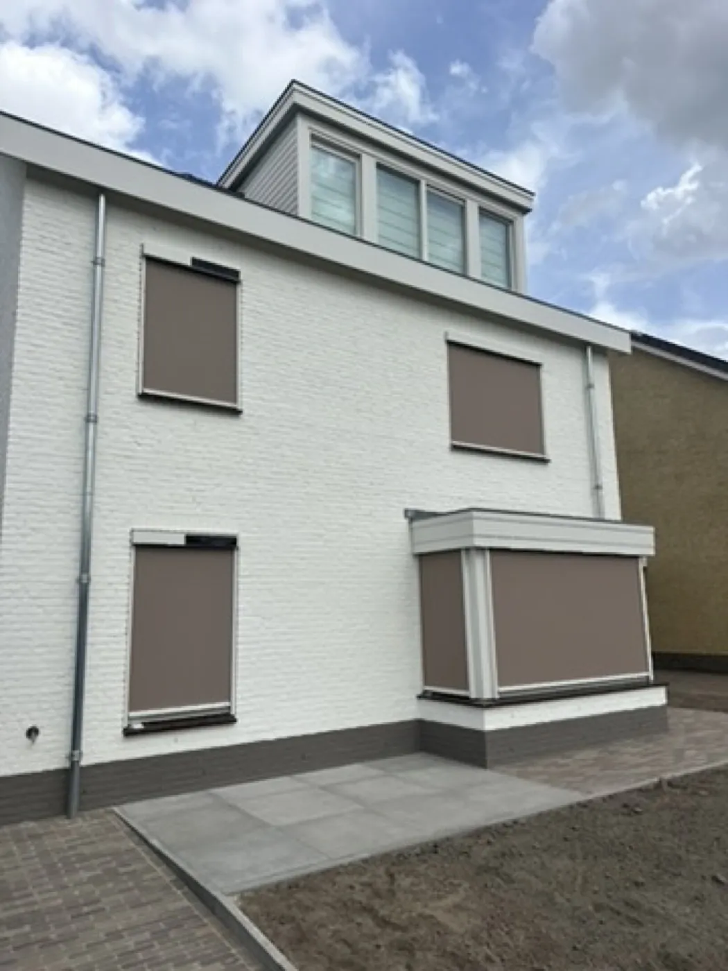 Witte nieuwbouwwoning met taupe screens