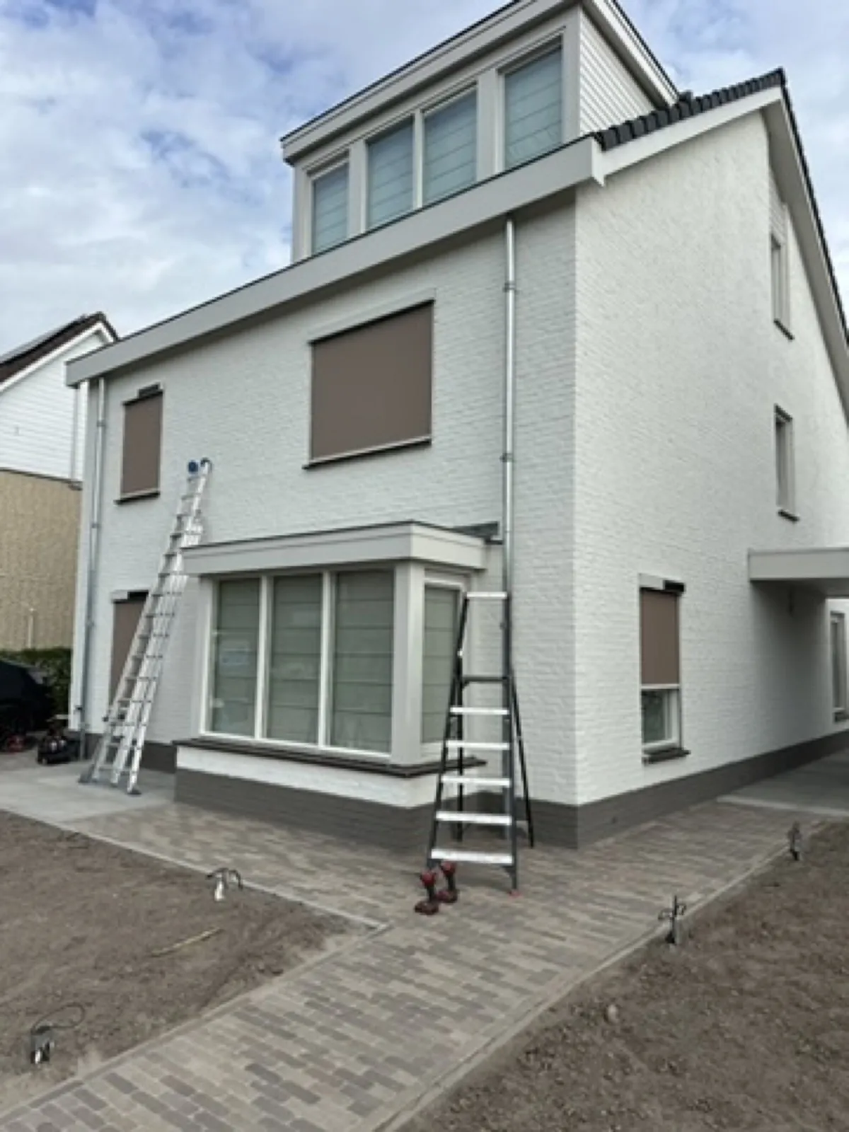 Witte villa met taupe screens, tijdens de montage door ons eigen team