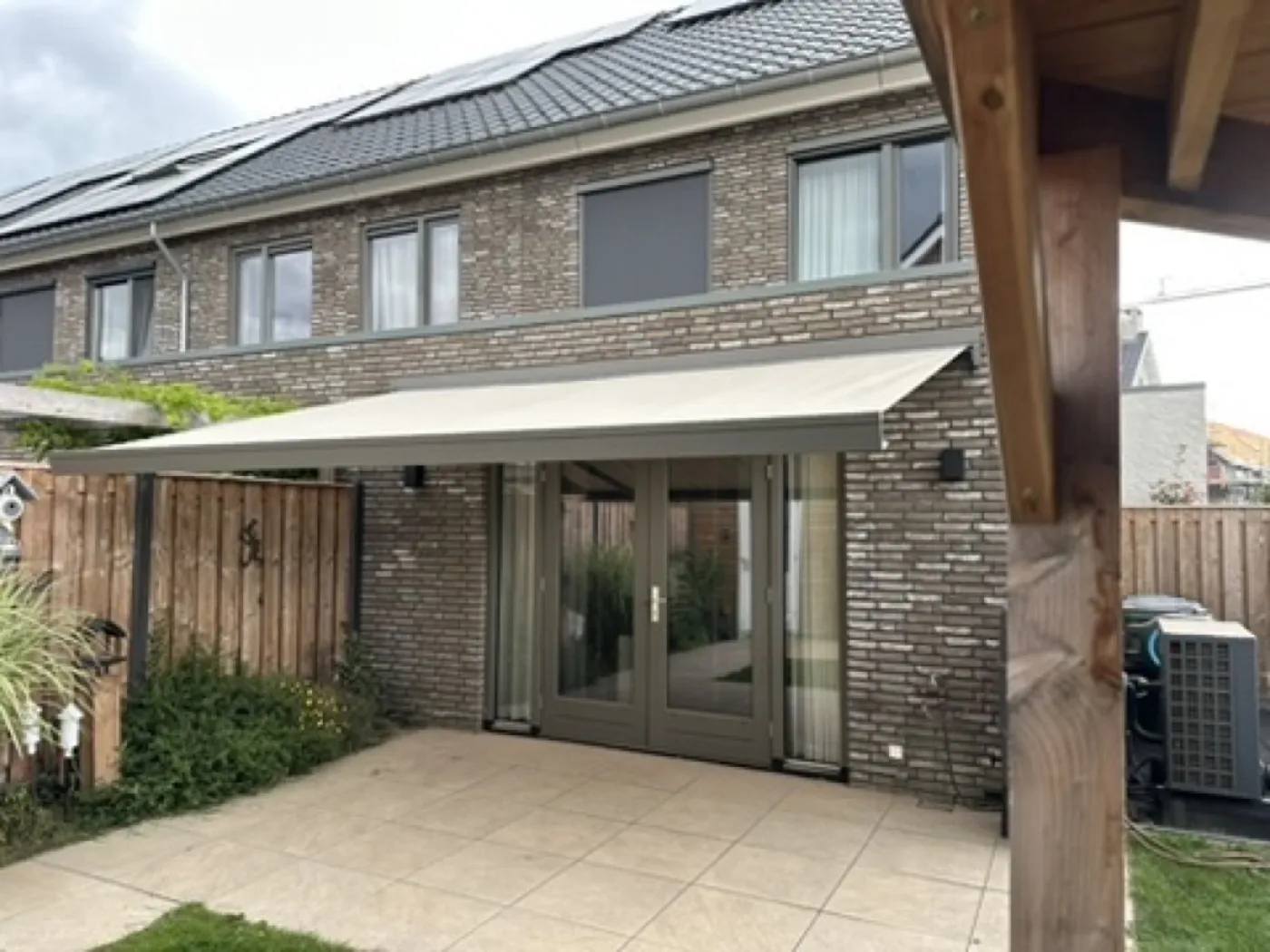 Zonnescherm uitgeschoven boven een terras bij een rijtjeshuis